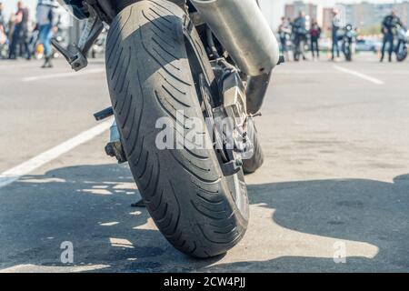 Primo piano della motocicletta delle ruote posteriori a livello del suolo. Mettere a fuoco la ruota posteriore. Dettagli di un closeup motociclistico. Foto Stock