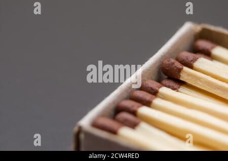 Corrispondenza in scatola, sfondo cartone. Fotografia macro. Primo piano. Un sacco di partite che giacciono in un matchbox su uno sfondo nero Foto Stock