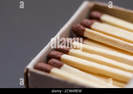 Corrispondenza in scatola, sfondo cartone. Fotografia macro. Primo piano. Un sacco di partite che giacciono in un matchbox su uno sfondo nero Foto Stock
