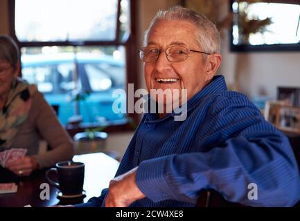 Ritratto di una coppia sorridente senior a Home seduta a Table Giocare le carte insieme Foto Stock