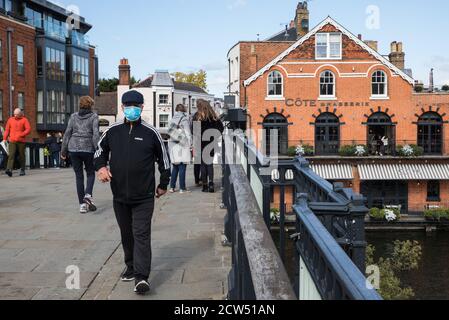 Windsor, Regno Unito. 26th Settembre 2020. Un uomo che indossa una copertura per il viso per prevenire la diffusione del coronavirus attraversa il Windsor Bridge. Il Royal Borough di Windsor e Maidenhead è consapevole di un aumento delle infezioni locali da coronavirus, ha un piano di gestione dell'epidemia COVID-19 per cercare di garantire che i numeri non aumentino ulteriormente e ha richiesto l'accesso a più siti di test per il coronavirus con questo obiettivo in mente. Credit: Mark Kerrison/Alamy Live News Foto Stock