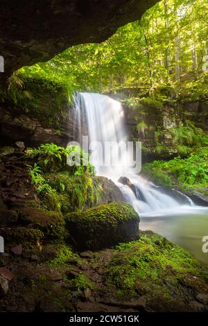 Incredibile bellezza della cascata panoramica chiamata Skok (il salto) nel villaggio sulla montagna vecchia chiamata Senokos, incorniciato da rocce e circondato da piante illuminate dal sole Foto Stock