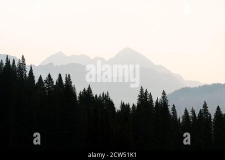 Le tranquille montagne del Colorado si stendono coperte da una fitta foschia di fumo, un chiaro ricordo dell'impatto del fuoco selvaggio su questi maestosi paesaggi. Foto Stock