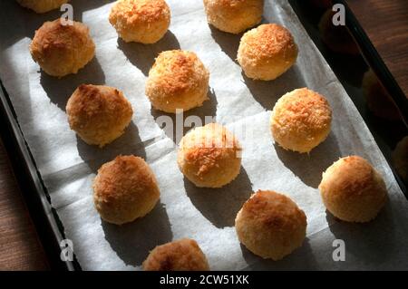 I biscotti natalizi al cocco si avvicinano su una teglia da forno sul tavolo. Panificio domestico della cucina. Dolci. Foto Stock