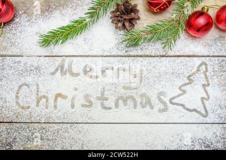Concetto di Natale o di sfondo di nuovo anno. Testo in farina e decorazione natalizia sul tavolo. Foto Stock