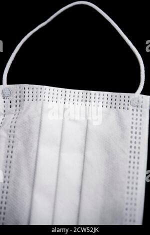 Maschera protettiva bianca isolata su sfondo nero Foto Stock