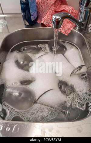 cucina dopo una cena più grande, festa di cottura, lavello con bicchieri sporchi, lavello Foto Stock