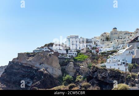 Bella vista di Oia, la famosa città con le sue tipiche case bianche in una giornata di sole. Isola di Santorini, Cicladi, Grecia, Europa. Foto Stock