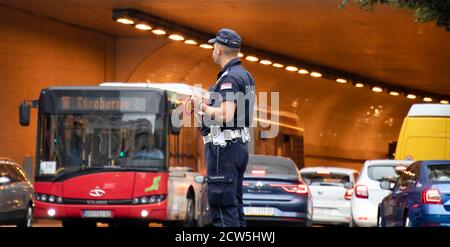Belgrado, Serbia - 25 settembre 2020: Poliziotto in servizio, in piedi all'incrocio con il traffico in movimento sfocato Foto Stock