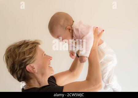 nonna abbracciando e sorridendo sua nipote Foto Stock