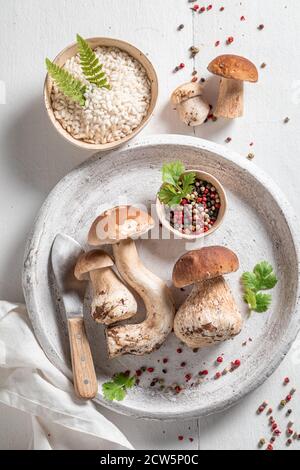 Preparazioni per risotto vegetariano a base di funghi e erbe selvatiche su tavolo di legno Foto Stock