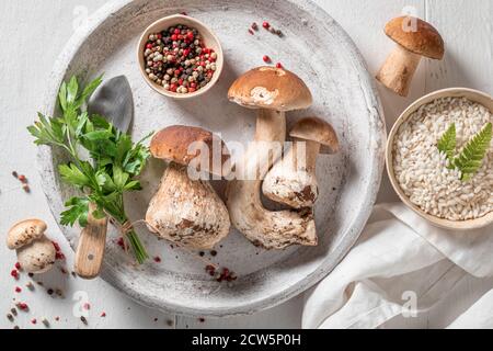 Ingredienti per risotto vegetariano a base di funghi selvatici ed erbe su tavolo di legno Foto Stock