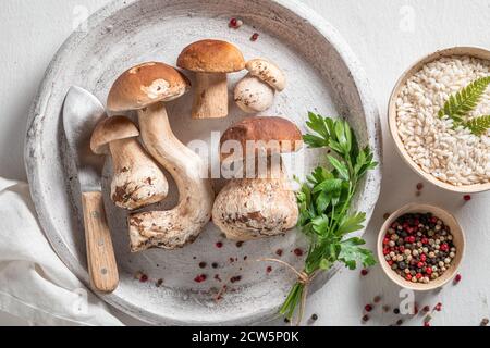 Ingredienti per risotti fatti in casa a base di funghi e erbe selvatiche su tavolo di legno Foto Stock