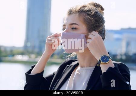 Giovane elegante donna d'affari in abbigliamento da formalwear che indossa una maschera protettiva Foto Stock