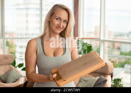 Giovane bionda bella sportiva tenendo in mano yoga pad con unghie prima esercizio fisico Foto Stock