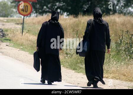 Monache ortodosse cristiane che camminano su una strada in Romania Foto Stock