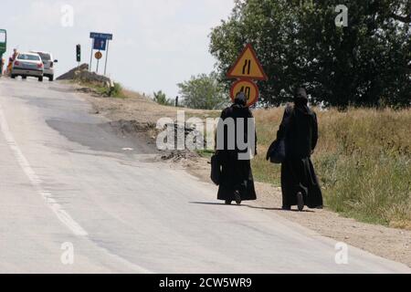 Monache ortodosse cristiane che camminano su una strada in Romania Foto Stock