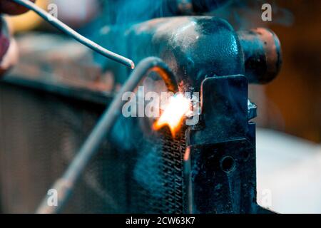 Saldatrici radiatori in rame per auto con torcia a gas Foto Stock