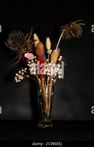 foto verticale d'arte di un bouquet di fiori secchi primo piano su sfondo nero Foto Stock