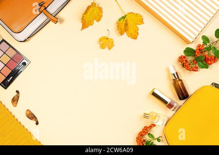 Posa piatta e vista dall'alto di prodotti cosmetici e cosmetici di bellezza set su sfondo autunno foglie gialle con copyspace. Concetto di bellezza per blogger. Foto Stock