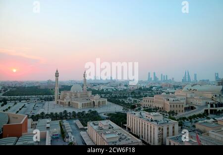 Vista aerea panoramica di Manama con al Fateh Grand Moschea e gruppo di simboli iconici contro il tramonto color pastello Cielo Foto Stock