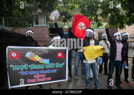 Kathmandu, Nepal. 28 Settembre 2020. I manifestanti che indossano schermi facciali tengono un cartello e un cartello mentre cantano slogan durante la manifestazione al di fuori dell'ambasciata cinese a Kathmandu.UN gruppo della società civile in Nepal ha lanciato proteste contro la Cina per aver presumibilmente costruito edifici sul territorio del paese nel distretto di Humla. Gli attivisti hanno cantato slogan come 'Return Nepal's Land' e 'stop espansionismo cinese'. Credit: SOPA Images Limited/Alamy Live News Foto Stock