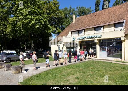 Issigeac, Francia: Luglio 2020: I clienti in coda per prelevare contanti da un cashpoint presso una filiale della banca Credit agricole Foto Stock