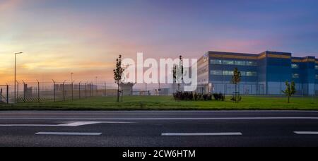 Strada che conduce al Centro di adempimento Amazon al mattino nebbia Foto Stock