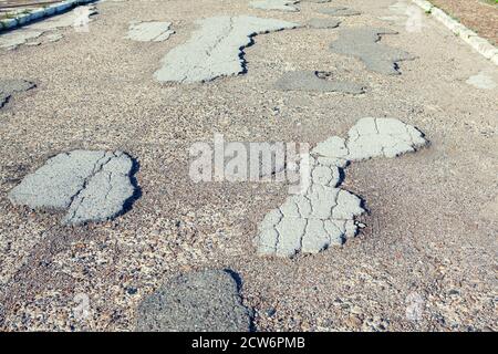 Superficie stradale rotta . Strada urbana con asfalto danneggiato Foto Stock