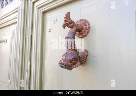 Maniglia medievale della porta pesce favoloso alla superficie di legno della porta Foto Stock