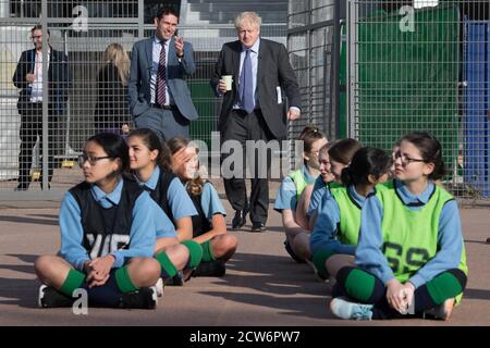 Il primo ministro Boris Johnson incontra gli alunni e partecipa oggi a una partita di cricket durante una lezione di sport alla Ruislip High School, nella sua circoscrizione di Uxbridge, a Londra ovest. Foto Stock