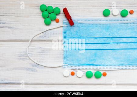 Flatlay medico con pillole colorate e maschera. Concetto medico di nuovo anno. Spazio per il testo. Foto Stock