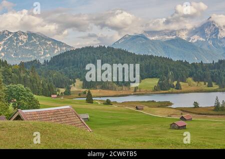 Splendido paesaggio montano con capanne di montagna e un lago di montagna nelle alpi. Foto Stock