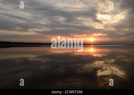 Il maestoso tramonto si riflette nel tranquillo lago d'acqua Foto Stock