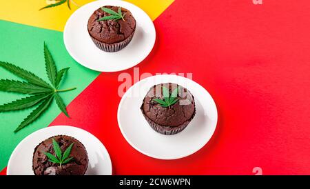 Muffin con cupcake di cioccolato alla marijuana e cbd con erbacce. Farmaci per la canapa di marijuana medica nel dessert alimentare. Muffin alle erbe infestate con cannabis e foglie di cannabis serviti Foto Stock