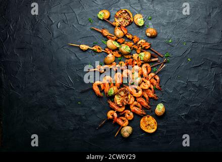 Gamberi alla griglia e cozze su spiedini di legno. Foto Stock