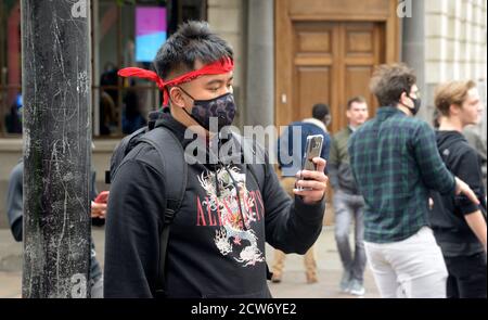 Uomo asiatico in bandana rossa e maschera facciale Foto Stock