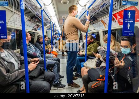 Londra, Regno Unito. 28 Settembre 2020. Il numero di passeggeri rimane basso sulla metropolitana, ma ora sono in aumento e i treni sono moderatamente occupati, in particolare nelle ore di punta. Proprio come il governo inizia a rafforzare la sua guida Coronavirus (covid 19) di nuovo. Coloro che viaggiano per lo più indossare maschere dopo essere diventati obbligatori sui trasporti pubblici. Credit: Guy Bell/Alamy Live News Foto Stock