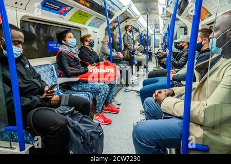 Londra, Regno Unito. 28 Settembre 2020. Il numero di passeggeri rimane basso sulla metropolitana, ma ora sono in aumento e i treni sono moderatamente occupati, in particolare nelle ore di punta. Proprio come il governo inizia a rafforzare la sua guida Coronavirus (covid 19) di nuovo. Coloro che viaggiano per lo più indossare maschere dopo essere diventati obbligatori sui trasporti pubblici. Credit: Guy Bell/Alamy Live News Foto Stock