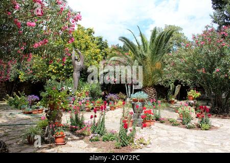 Giardini e statua di Francesco d'Assisi tra le rovine Dell'antica Garrison romana Città di Capernaum in Israele Foto Stock