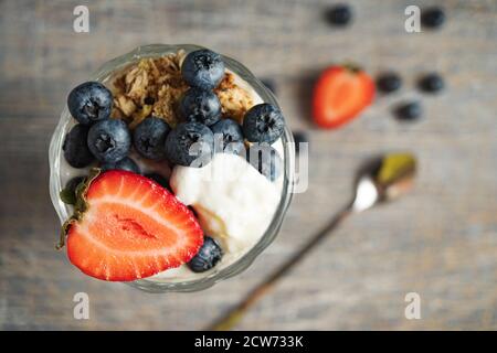 Gelato con fragole e mirtilli in un vetro alto, vista dall'alto Foto Stock