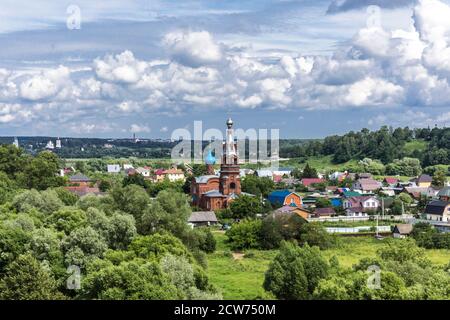 A metà estate. Chiesa di mattoni tra cottage e alberi verdi. Vista dalla collina. Città Provinciale di Borovsk in Russia. Foto Stock