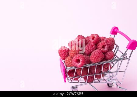 Primo piano lamponi freschi maturi in carrello supermercato, sano concetto di mangiare, sfondo alimentare con frutti di bosco estivi Foto Stock