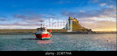 Castello di Lindisfarne e barca da pesca ar tramonto-castello del XVI secolo, Isola Santa, Lindisfarne, Northumberland, Inghilterra Foto Stock