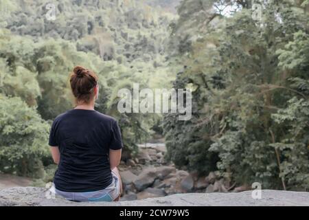 ragazza siede su una pietra nella foresta. foto di alta qualità Foto Stock