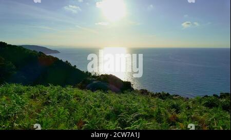 Tramonto con riflessi su una montagna con felci dal Costa del Mar Cantabriano Foto Stock