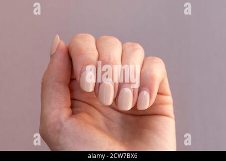 Unghie con gel lucidante riccrescita. La donna non è stata in grado di ottenere una manicure in tempo a causa della necessità di osservare l'isolamento sociale. I saloni per unghie sono chiusi a causa Foto Stock