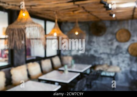 Sfondo sfocato sfocato dell'hipster cafè alla moda loft. Decorazioni in legno fatte a mano e pareti in cemento grigio. Foto Stock