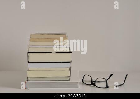 Stack di libri, libri di vari temi, occhiali da lettura, vista laterale, sfondo bianco, Brasile, America del Sud, spazio di copia, libri colorati, zoom Foto Stock