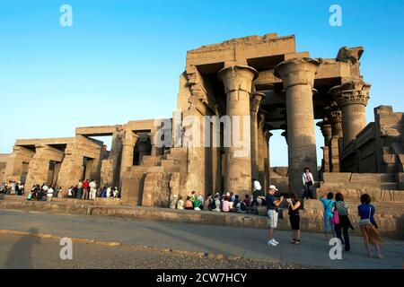 I turisti si affollano intorno alle rovine del tempio Kom Ombo sul fiume Nilo in Egitto nel tardo pomeriggio. Il tempio fu costruito nel II secolo a.C. Foto Stock